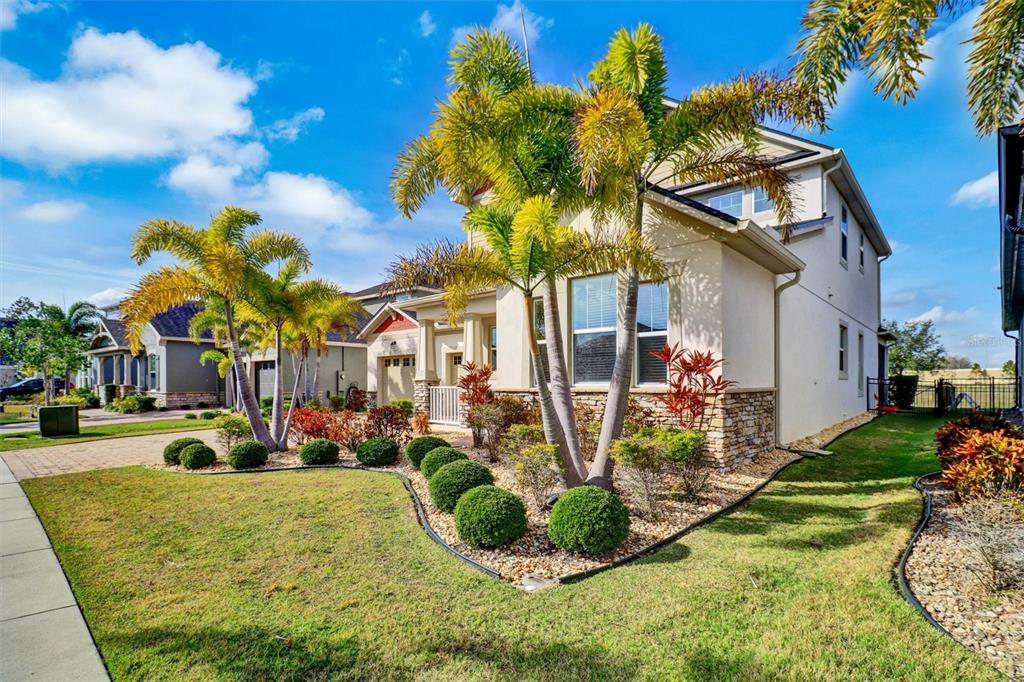 A two-story house with a palm-filled front yard, stone accents, and a paved driveway — 7921 CORKFIELD AVENUE, ORLANDO, FL