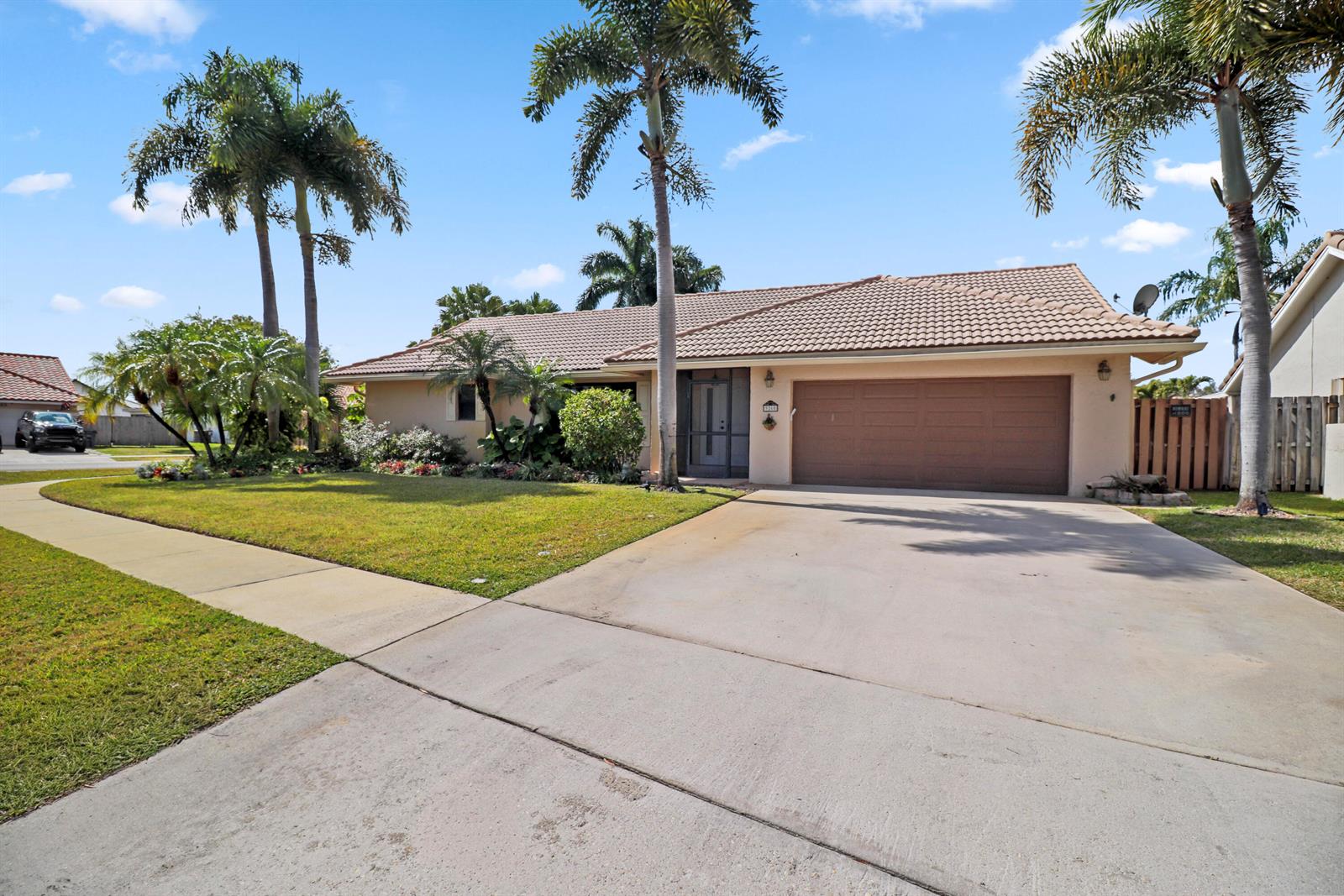 A single-story house with a tile roof, two-car garage, and palm trees in the front yard — 9260 Laurel Green Drive, Boynton Beach FL 33437, BOYNTON BEACH, FL