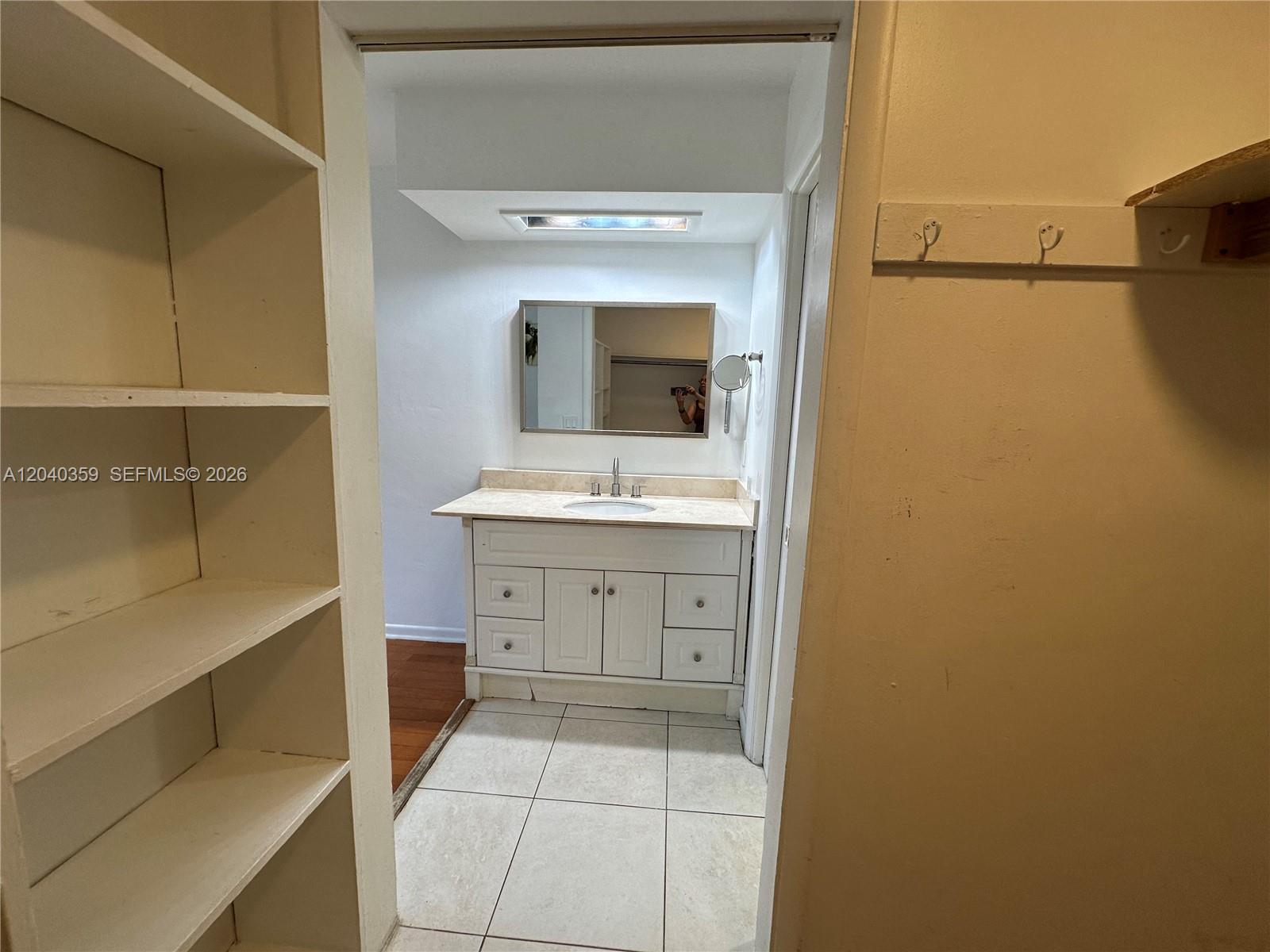 A bathroom features a white vanity with a mirror and tiled flooring — 819 NE 8th St # 2, Hallandale Beach FL 33009, HALLANDALE BEACH, FL