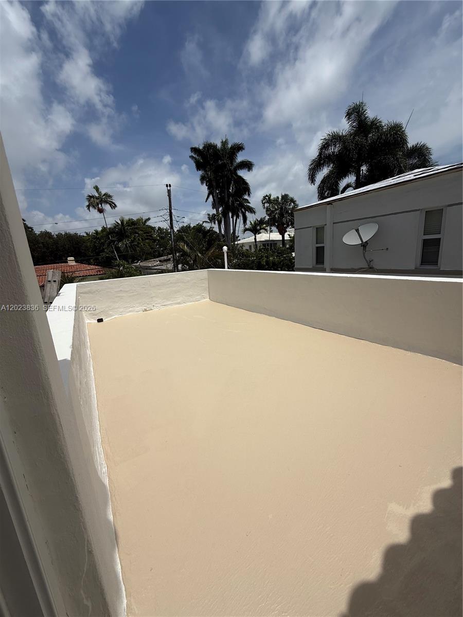 A flat, beige-colored rooftop terrace is enclosed by low white walls under a cloudy sky — 6312 Alton Rd, Miami Beach FL 33141, MIAMI BEACH, FL
