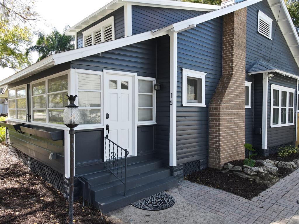 A dark blue house with white trim, a brick chimney, and a front porch entrance — 16 N LAWSONA BOULEVARD, ORLANDO, FL