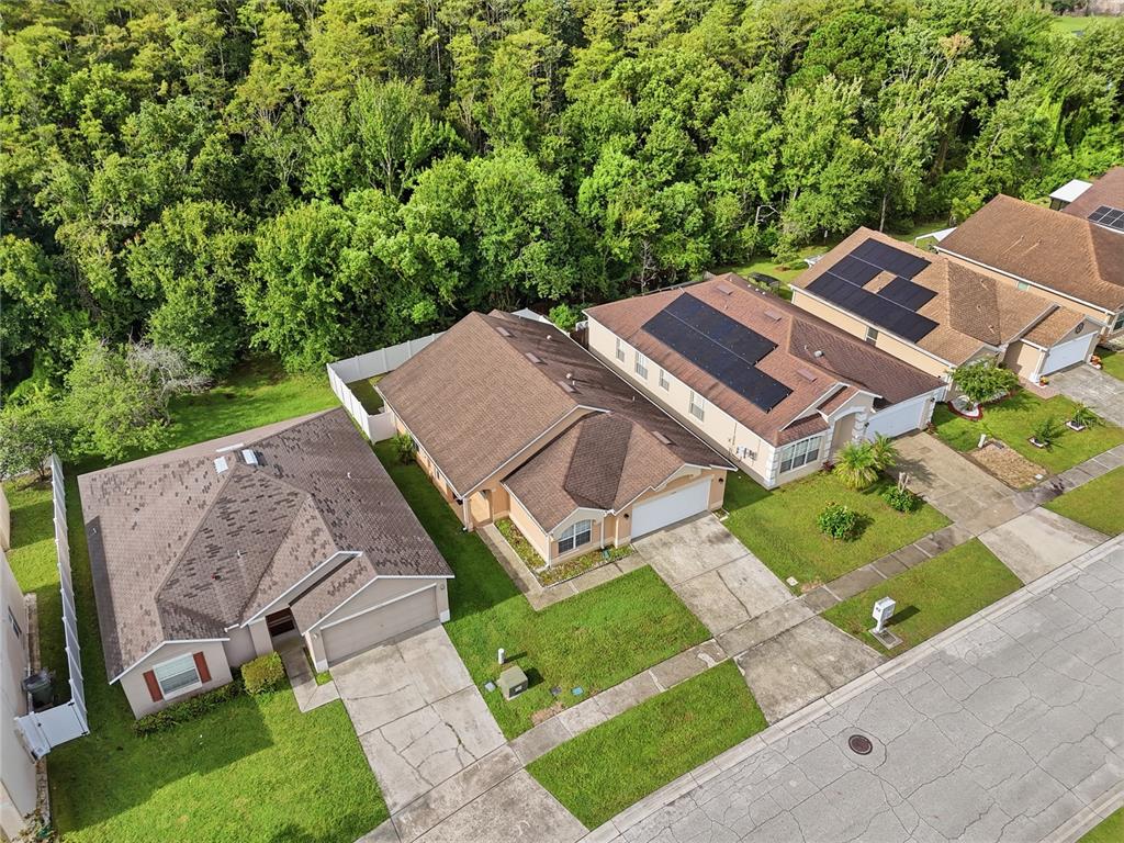 An aerial view shows a row of suburban houses with brown roofs and green lawns — 2350 TOPAZ TRAIL, KISSIMMEE, FL