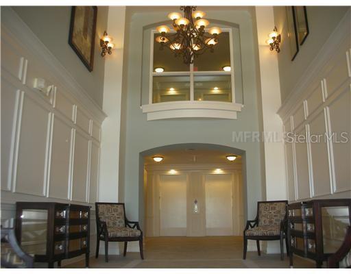 A formal lobby features a high ceiling, a large chandelier, two chairs, and elevator doors — 3368 ROBERT TRENT JONES DRIVE UNIT 40208, ORLANDO, FL