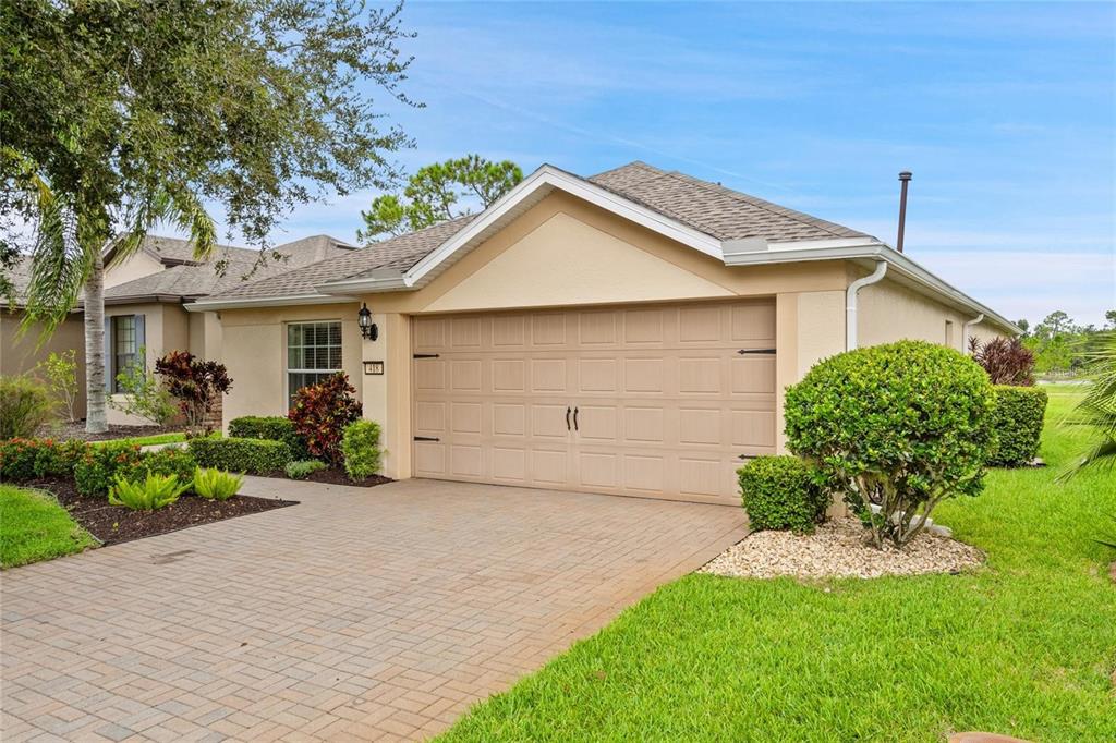 A beige single-story house with a two-car garage and a paved driveway — 418 DEL SOL AVENUE, DAVENPORT, FL