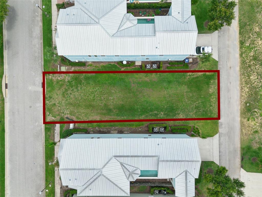 An aerial view shows a rectangular vacant lot situated between two houses — 1513 FAIRVIEW CIRCLE, REUNION, FL