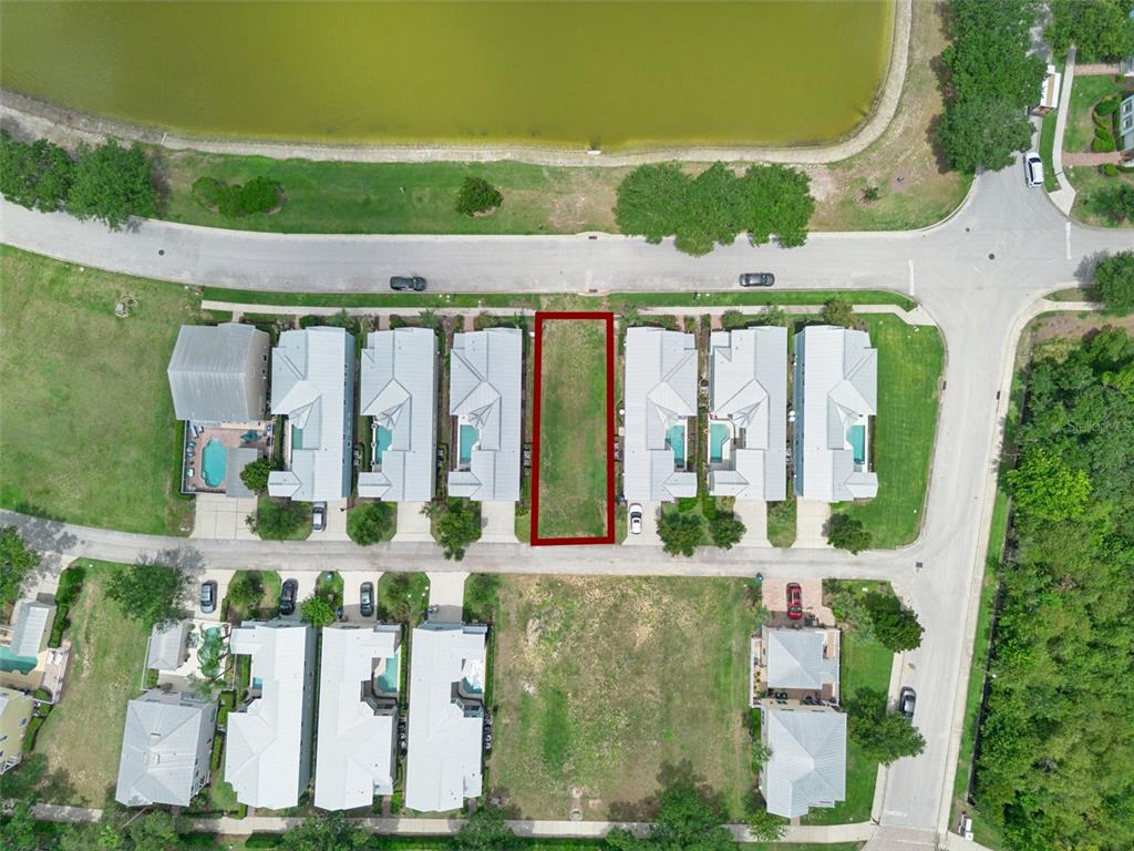 An aerial view shows a vacant rectangular residential lot outlined in red between two houses — 1513 FAIRVIEW CIRCLE, REUNION, FL