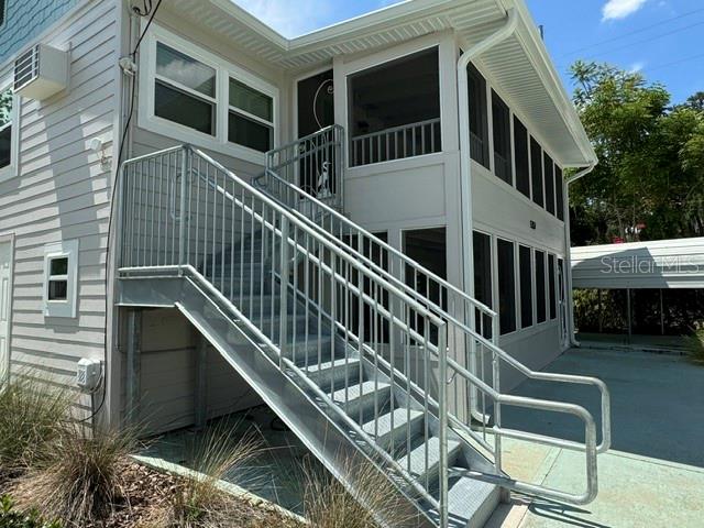 An exterior view of a two-story building featuring a metal staircase leading to an upper deck — 1357 LAKESHORE DRIVE UNIT 3, MOUNT DORA, FL