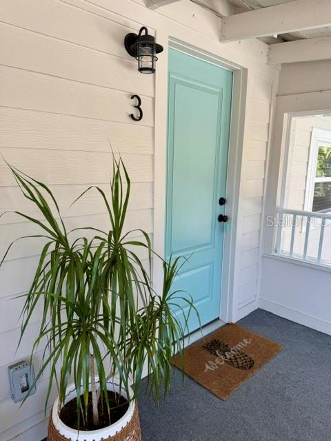 A light blue front door with the number three sits on a covered porch — 1357 LAKESHORE DRIVE UNIT 3, MOUNT DORA, FL