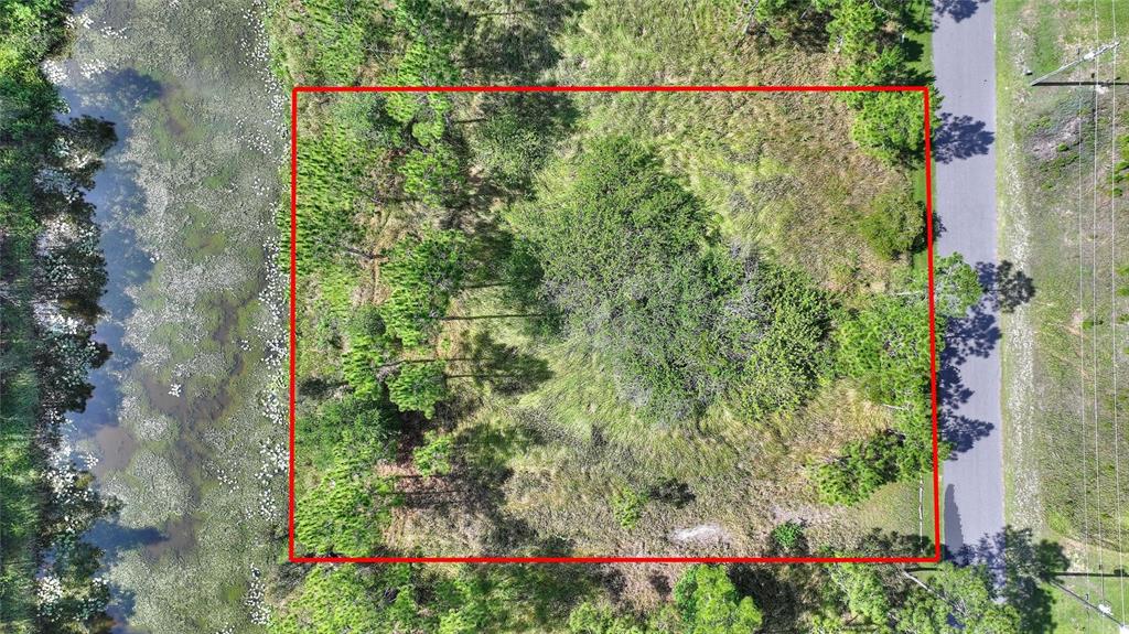 An aerial view shows a rectangular plot of land bordered by a road and water — 26 LANTANA DRIVE S, INDIAN LAKE ESTATES, FL