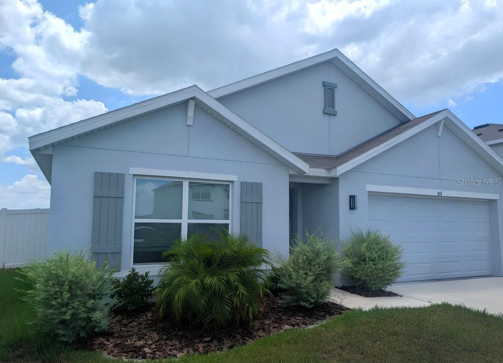 A light blue single-story house with a two-car garage and gray shutters — 801 ACE OUTLAW AVENUE, RUSKIN, FL