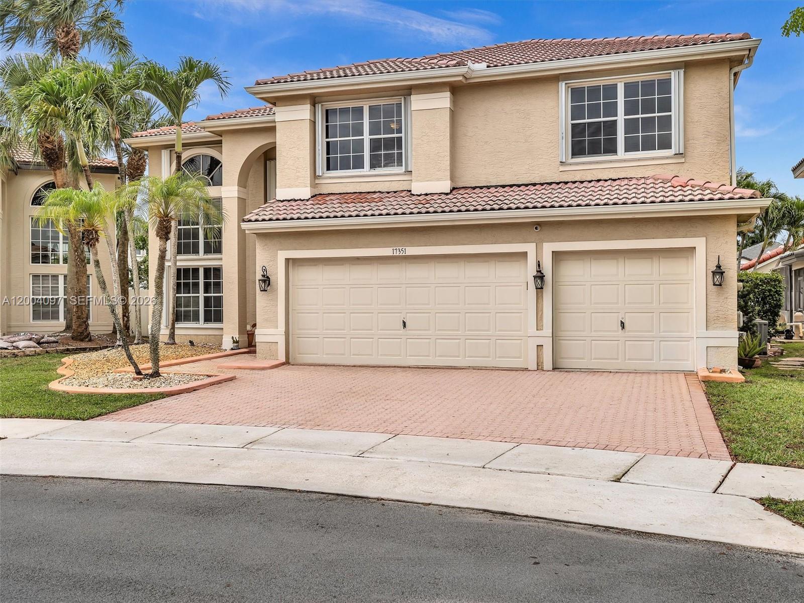 A two-story house with a beige stucco exterior, a tiled roof, and a three-car garage — 17351 SW 32nd Ct, Miramar FL 33029, MIRAMAR, FL