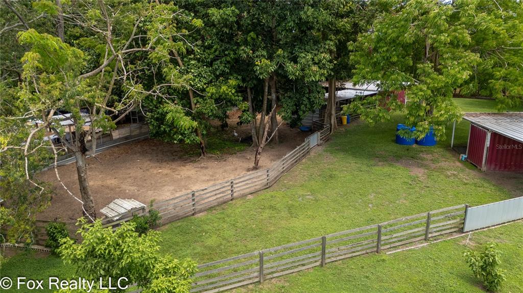 An aerial view shows a fenced grassy yard with trees and several small outbuildings — BO ESPINAL, AGUADA, PR
