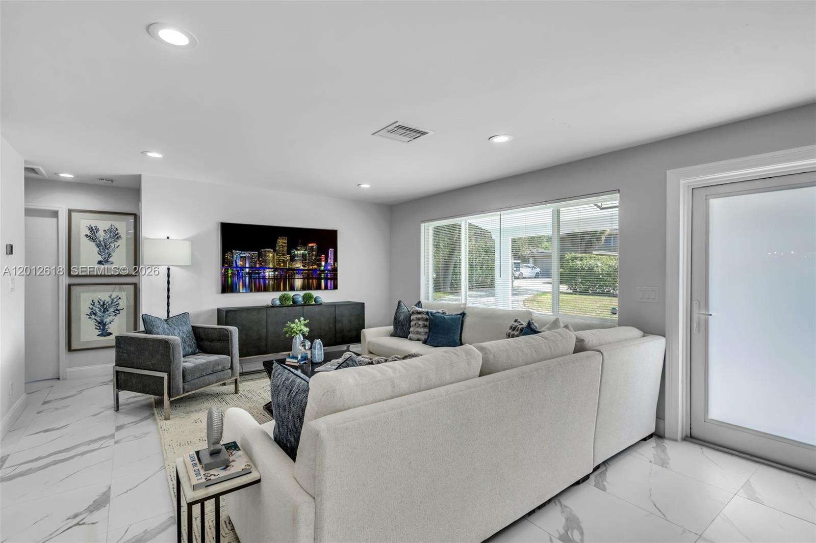 A living room features a white sectional sofa, gray armchair, and marble-look tile flooring — 465 NW 11th St, Boca Raton FL 33432, BOCA RATON, FL