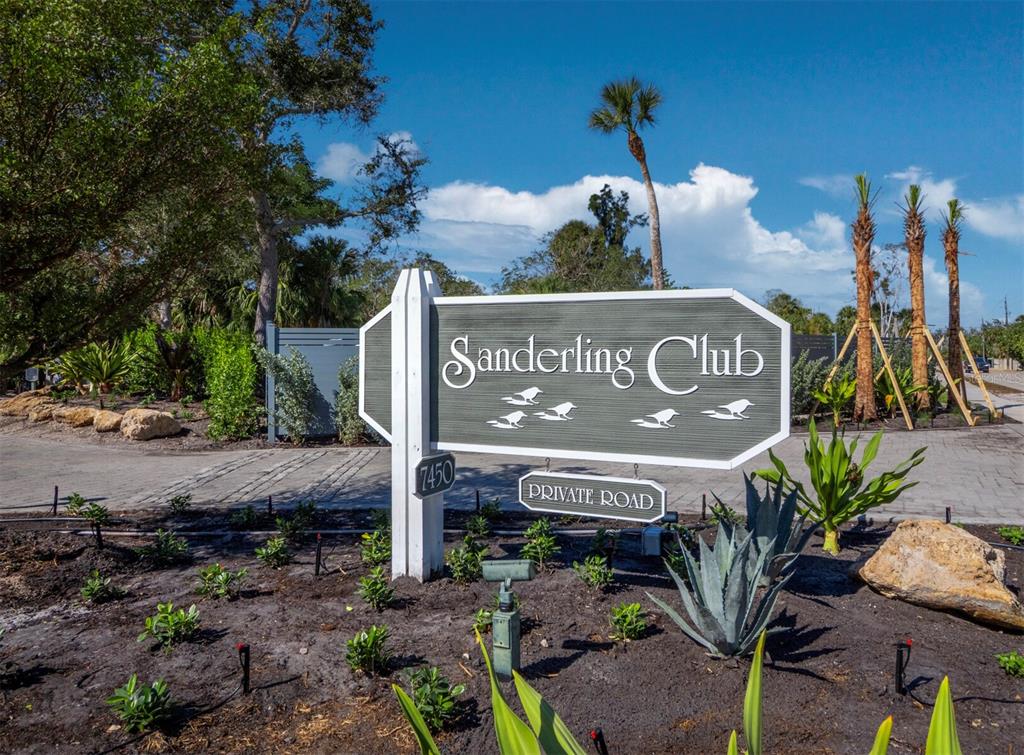 A sign for the Sanderling Club stands in a landscaped garden with palm trees — 7219 PINE NEEDLE ROAD, SARASOTA, FL