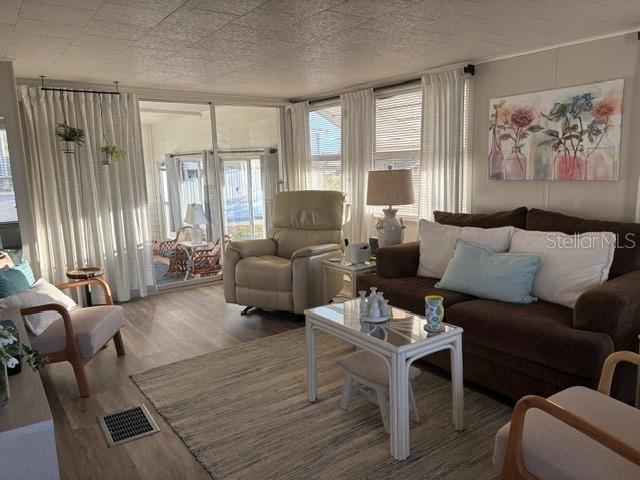A living room features a brown sofa, a beige recliner, and a white coffee table — 740 CAREFREE, VENICE, FL
