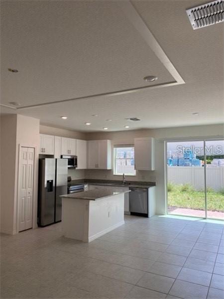 A kitchen with white cabinets, stainless steel appliances, a center island, and tile flooring — 4306 SAILPLANE COURT, WESLEY CHAPEL, FL