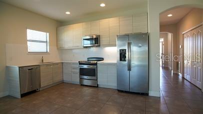 A kitchen with light wood cabinets, stainless steel appliances, and tile flooring — 161 KENNY BOULEVARD, HAINES CITY, FL