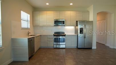 A kitchen with light wood cabinets, stainless steel appliances, and tile flooring — 161 KENNY BOULEVARD, HAINES CITY, FL