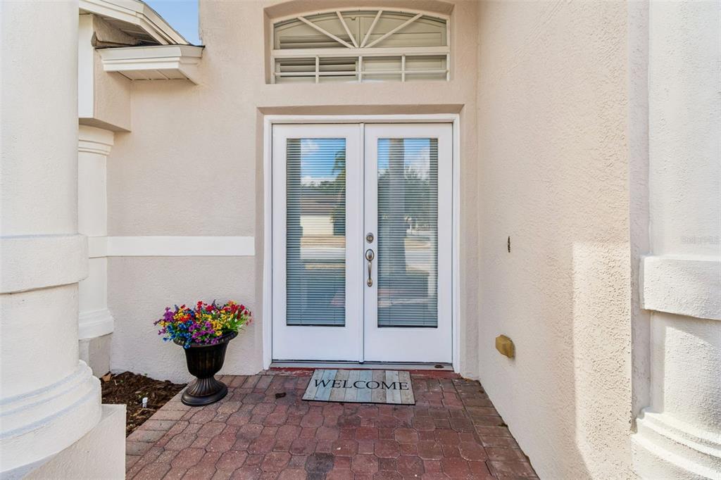 A front entryway features double glass doors with blinds, a brick porch, and a flower pot — 353 BAY ARBOR, OLDSMAR, FL