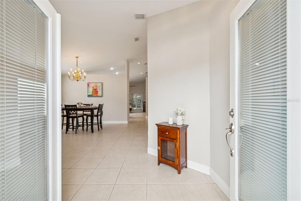 A view from an entryway into a dining area with tile floors and a chandelier — 353 BAY ARBOR, OLDSMAR, FL