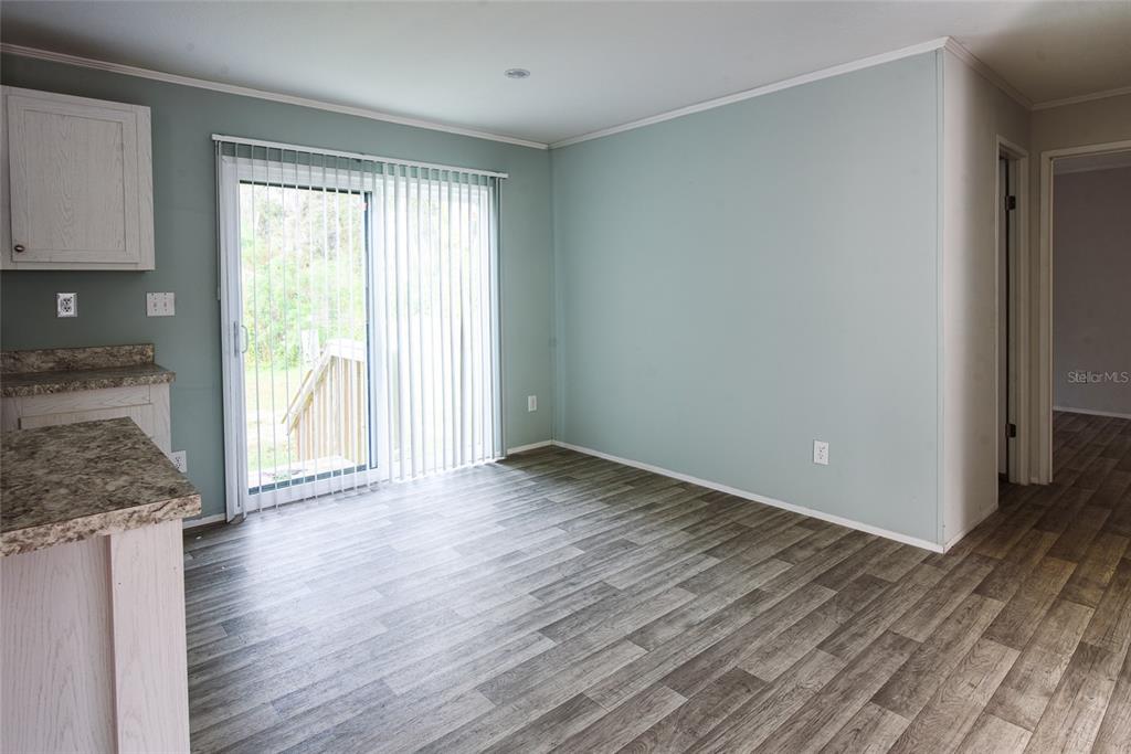 A dining area features light blue walls, wood-look flooring, and a sliding glass door — 3205 J AND J MANOR ROAD, LAKELAND, FL