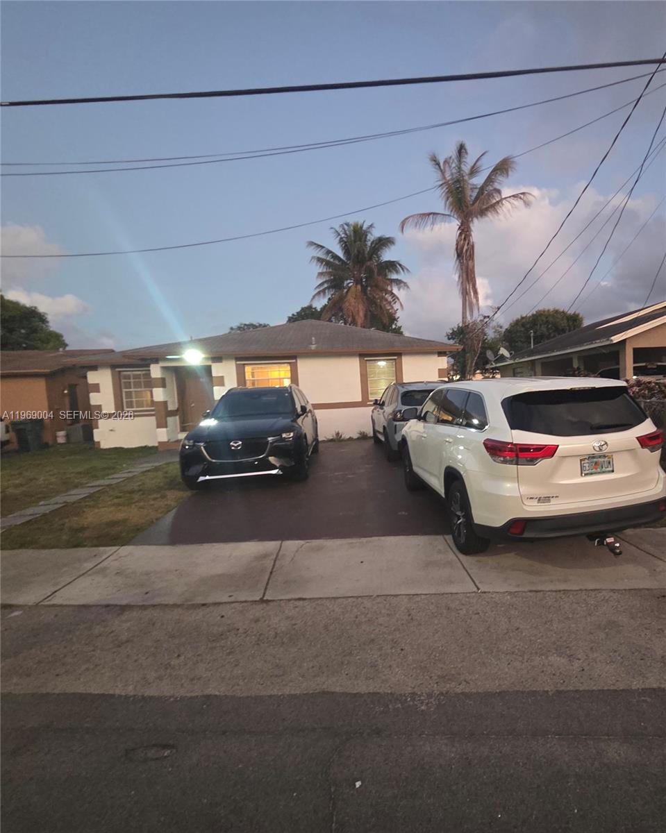 A single-story house with a driveway featuring three parked cars and two palm trees — 230 NW 7th Ave, Dania Beach FL 33004, DANIA BEACH, FL