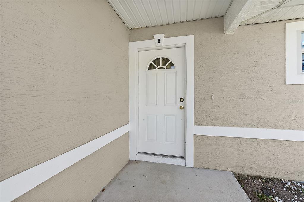 A white front door labeled with the letter B sits on a concrete porch — 18 PROSPECT LANE UNIT A & B, PALM COAST, FL