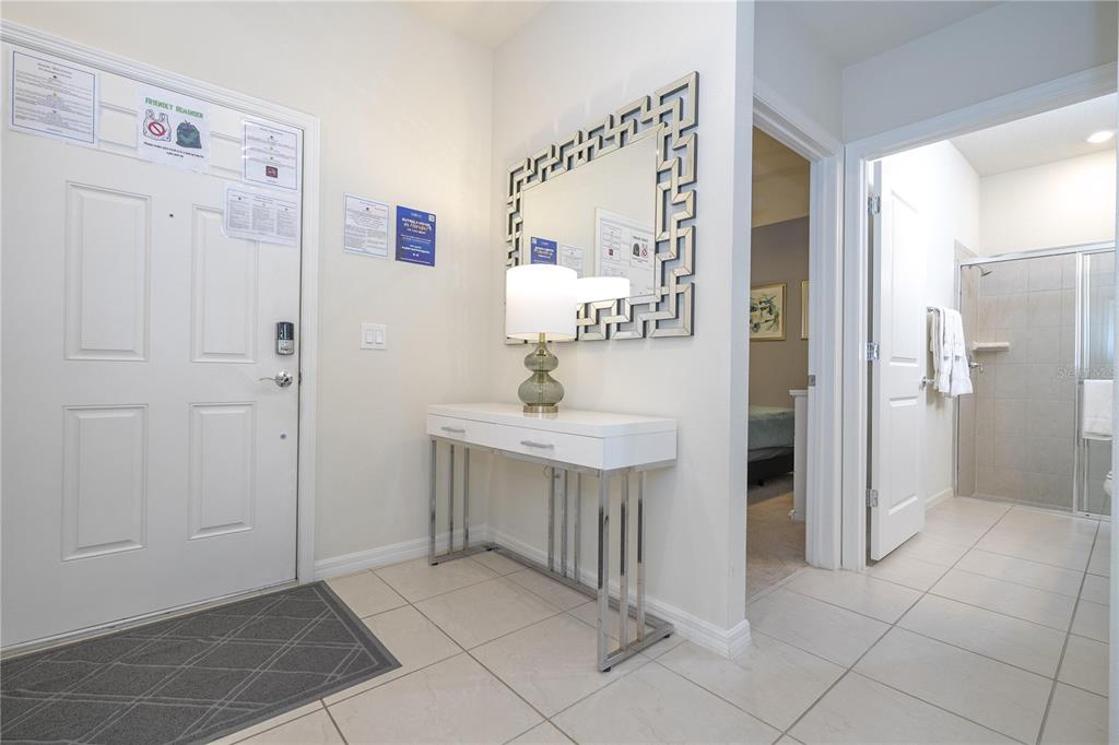 An entryway features a white console table, a decorative mirror, and a tiled floor — 197 JETTY WAY, DAVENPORT, FL