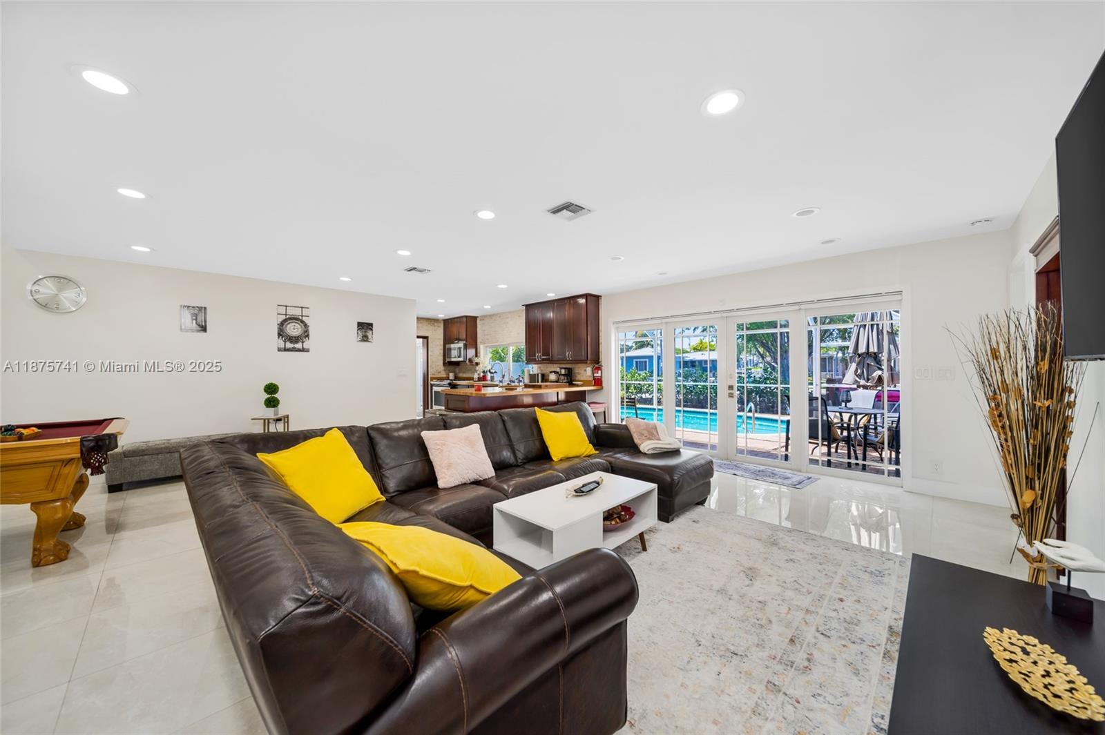A living room with a large brown sectional, pool table, and sliding glass doors to a pool — 31 SE 12th St, Pompano Beach FL 33060, POMPANO BEACH, FL