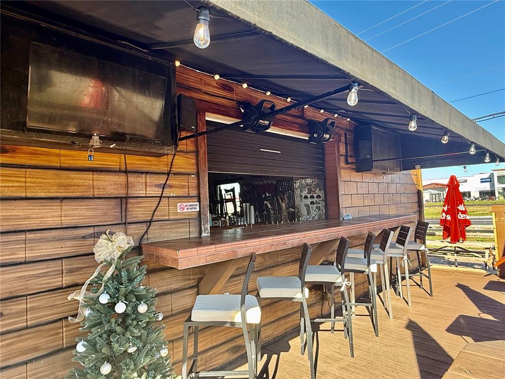 An outdoor bar area features a wooden counter, several bar stools, and string lighting — 100 S WHITE CEDAR ROAD, SANFORD, FL