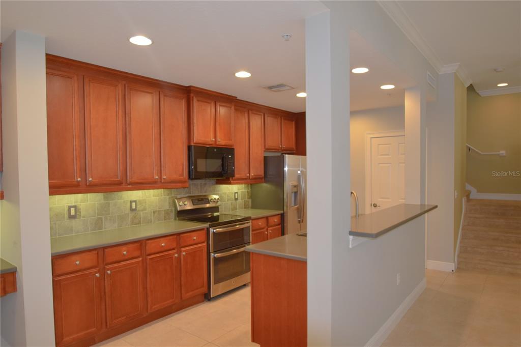 A kitchen features cherry wood cabinets, stainless steel appliances, and a breakfast bar — 1420 LAKE BALDWIN LANE, ORLANDO, FL