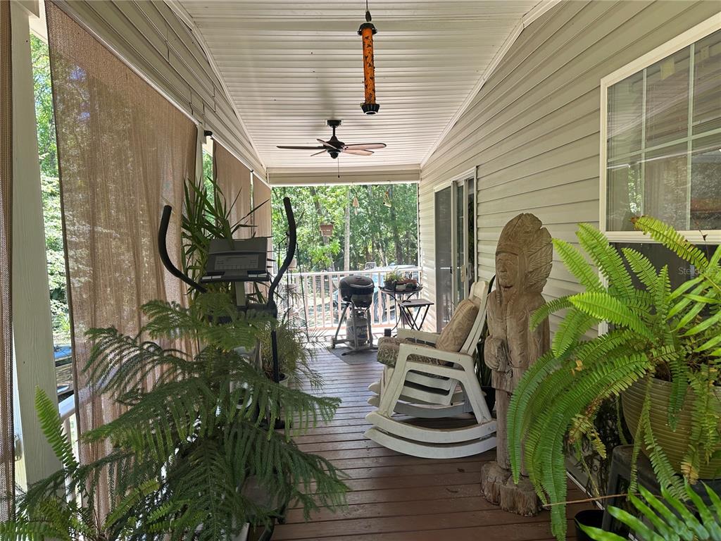 A light green manufactured home with a screened-in front porch and lattice skirting — 462 S DEW PLANT POINT, CRYSTAL RIVER, FL