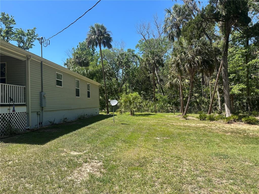 An open-concept kitchen and living area features dark wood cabinets, granite countertops, and tile flooring — 462 S DEW PLANT POINT, CRYSTAL RIVER, FL