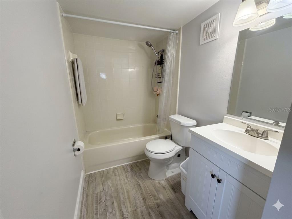 A bathroom features a white vanity, a toilet, and a shower-tub combination with tiled walls — 924 LAKE DESTINY ROAD UNIT E, ALTAMONTE SPRINGS, FL