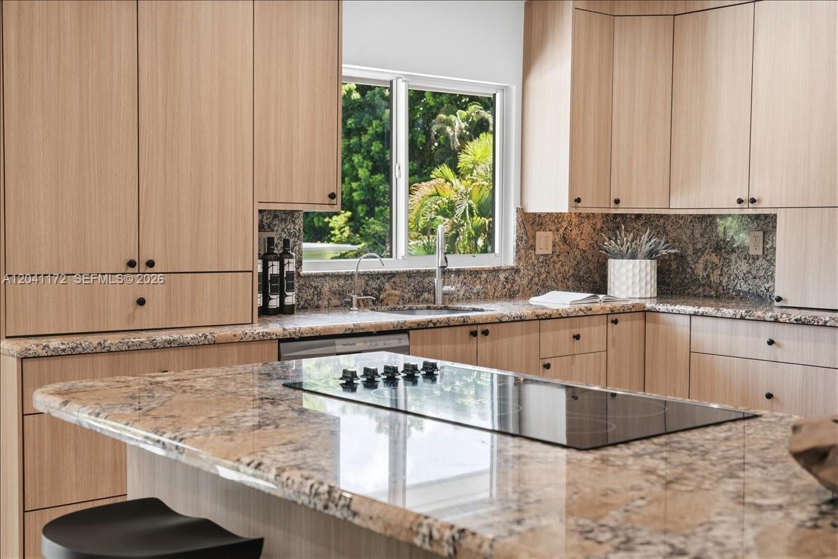 A kitchen features light wood cabinets, granite countertops, and a central island with a cooktop — 6250 SW 48th St, Miami FL 33155, MIAMI, FL