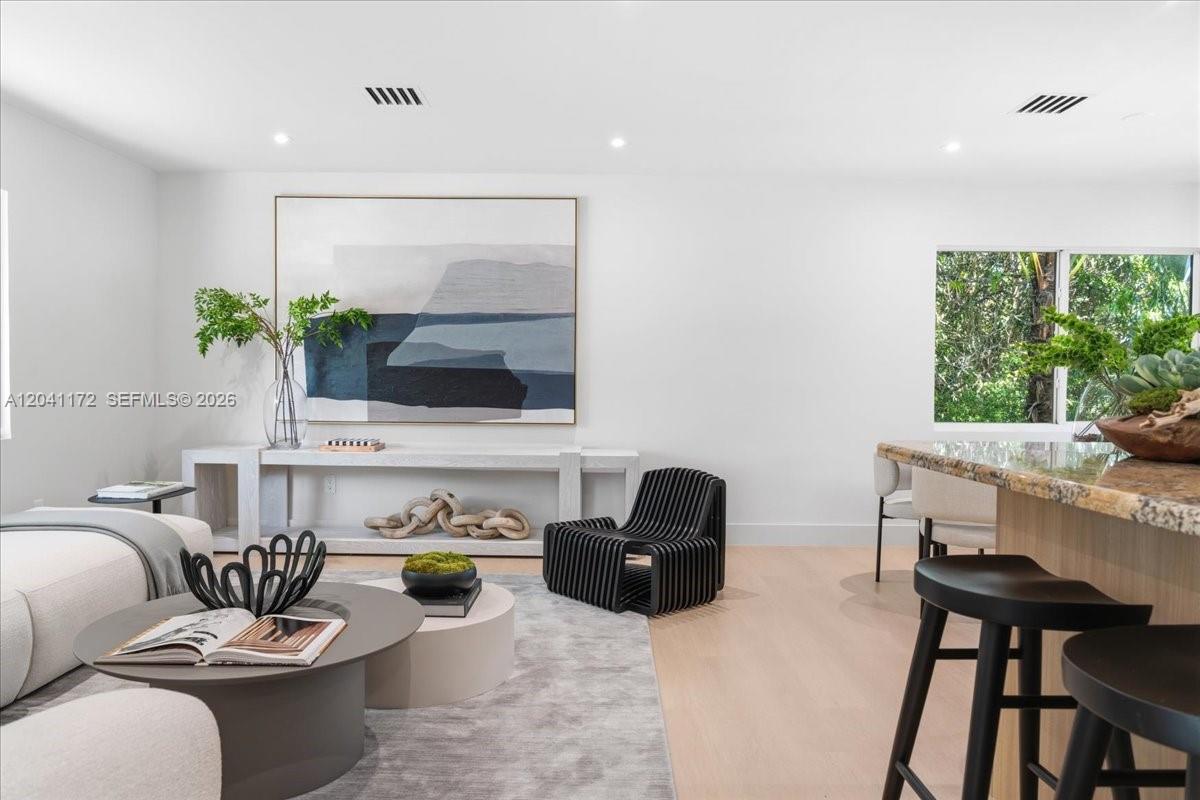 A modern living room features a white console table, abstract wall art, and a black chair — 6250 SW 48th St, Miami FL 33155, MIAMI, FL