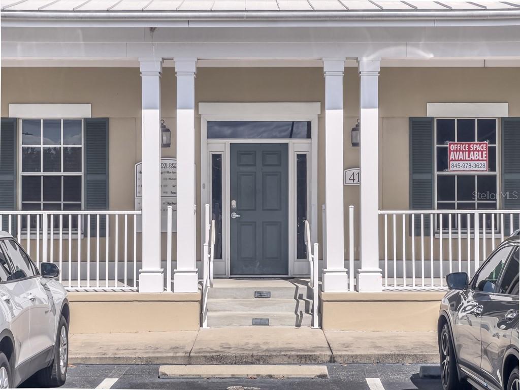 The exterior of a commercial building features a front porch with white columns and stairs — 411 APOLLO BEACH BOULEVARD UNIT 900, APOLLO BEACH, FL