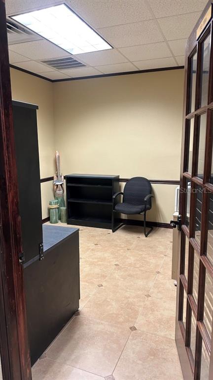 A small office with tan walls, tile flooring, a black bookshelf, and a black chair — 411 APOLLO BEACH BOULEVARD UNIT 900, APOLLO BEACH, FL