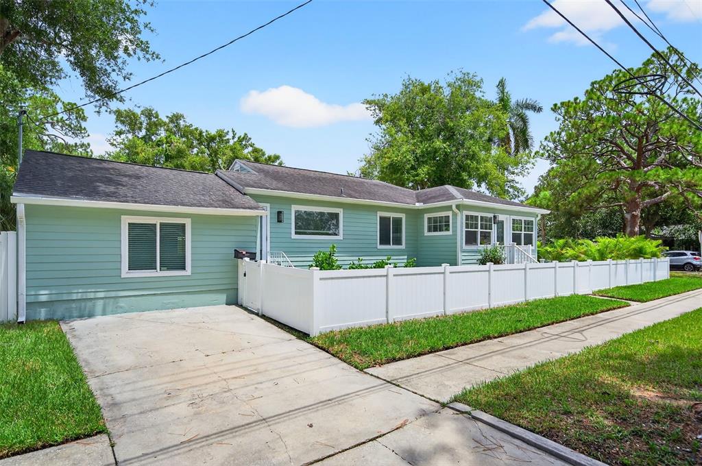 A light green single-story house with a white vinyl fence and a concrete driveway — 1846 3RD STREET S, ST PETERSBURG, FL