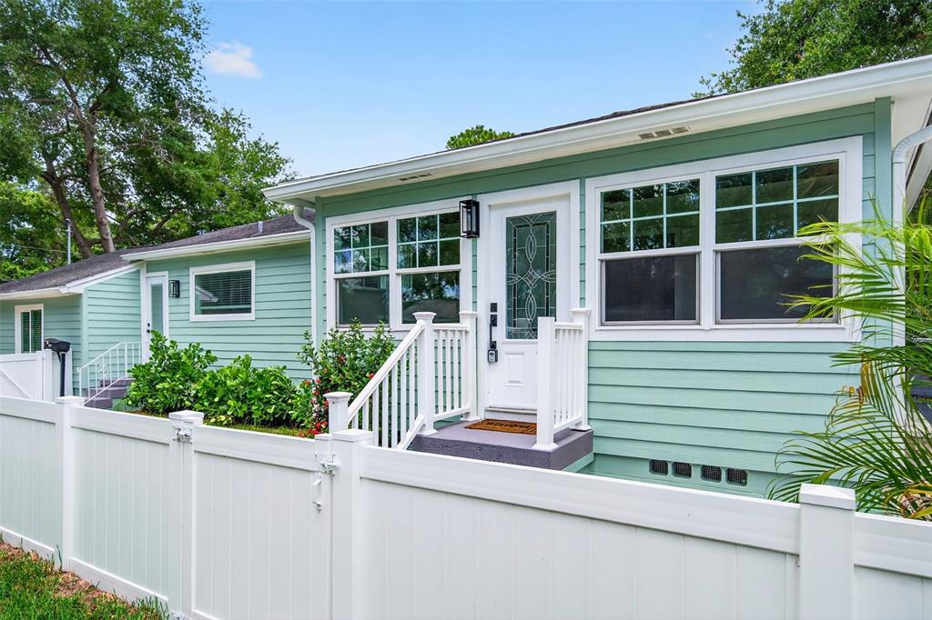 A light green house with white trim and a white vinyl fence in the yard — 1846 3RD STREET S, ST PETERSBURG, FL
