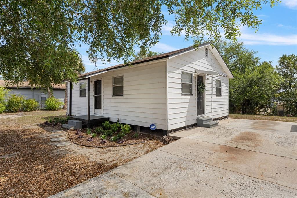 A white, single-story house with a concrete driveway and a small front garden — 3419 N 54TH STREET, TAMPA, FL