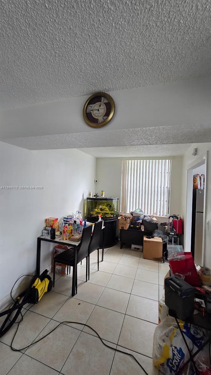 A dining area features a table with two chairs, a fish tank, and tiled flooring — 1748 NW 55th Ave # 101, Lauderhill FL 33313, LAUDERHILL, FL