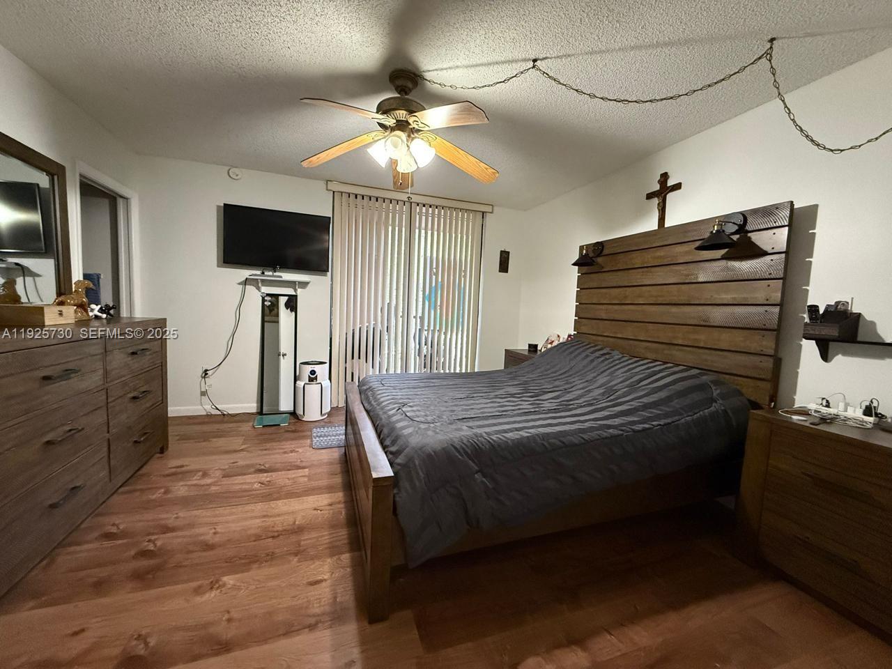 A bedroom features a wooden bed frame, a dresser, and a ceiling fan — 8600 SW 133rd Ave Rd # 310, Miami FL 33183, MIAMI, FL