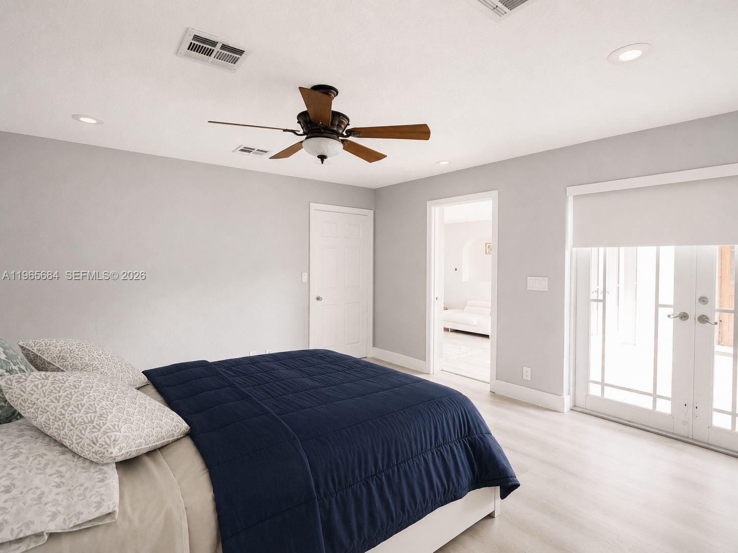 A bedroom features light gray walls, a ceiling fan, and glass doors leading outside — 901 SW 121 AVE, Davie FL 33325, DAVIE, FL
