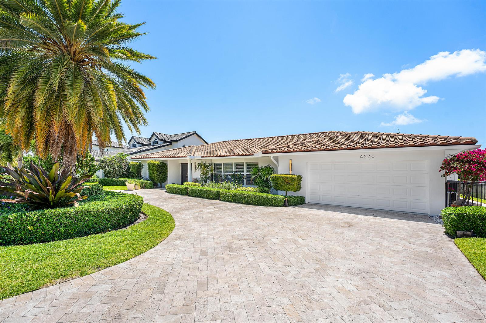 A single-story house with a white exterior, tiled roof, and a paved circular driveway — 4230 NE 24th Avenue, Lighthouse Point FL 33064, LIGHTHOUSE POINT, FL