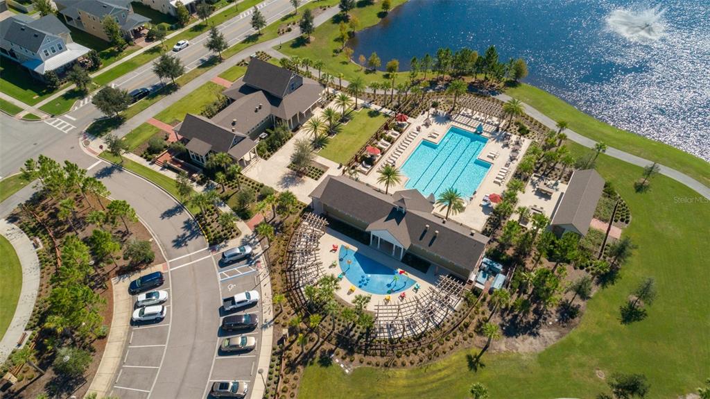 A row of three attached townhomes with gray siding, stone accents, and front porches — 8515 VEDDER LN, ORLANDO, FL