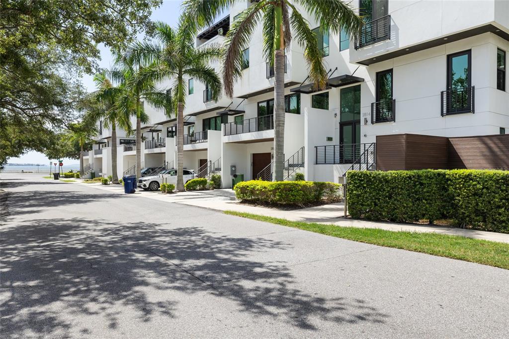 A row of modern white townhouses with palm trees and a street in the foreground — 2814 W BARCELONA STREET, TAMPA, FL