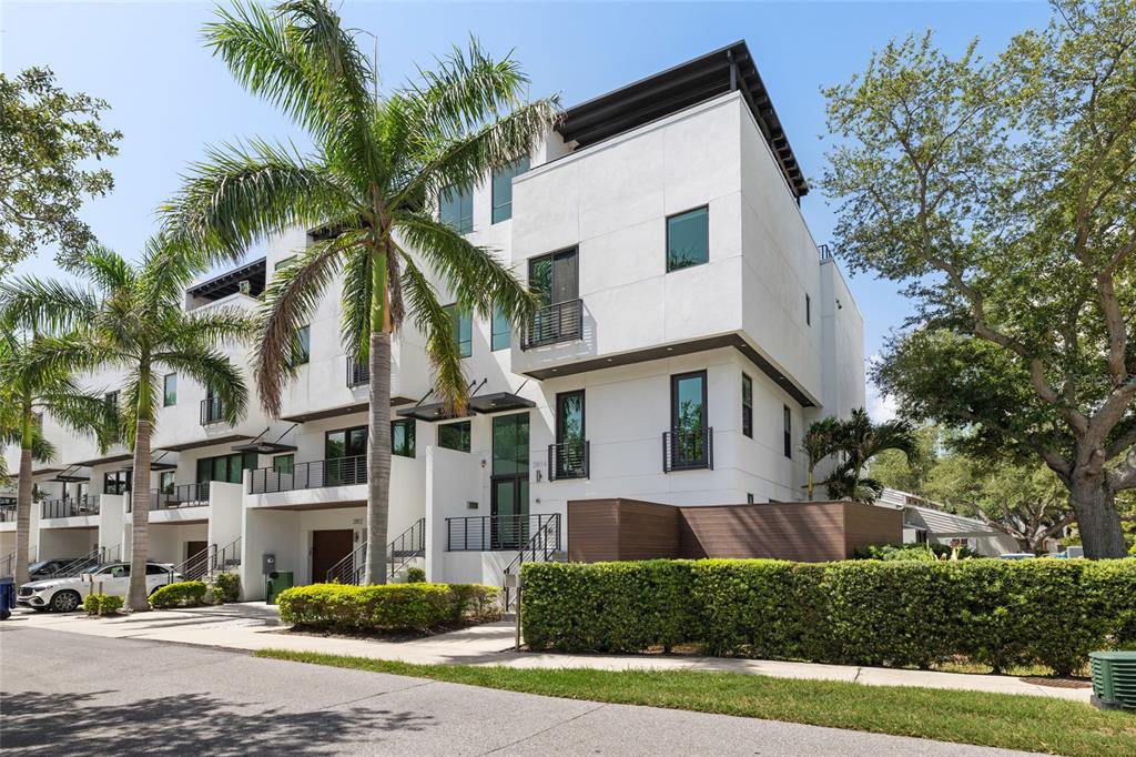 A modern three-story white townhouse with balconies, palm trees, and a manicured hedge — 2814 W BARCELONA STREET, TAMPA, FL