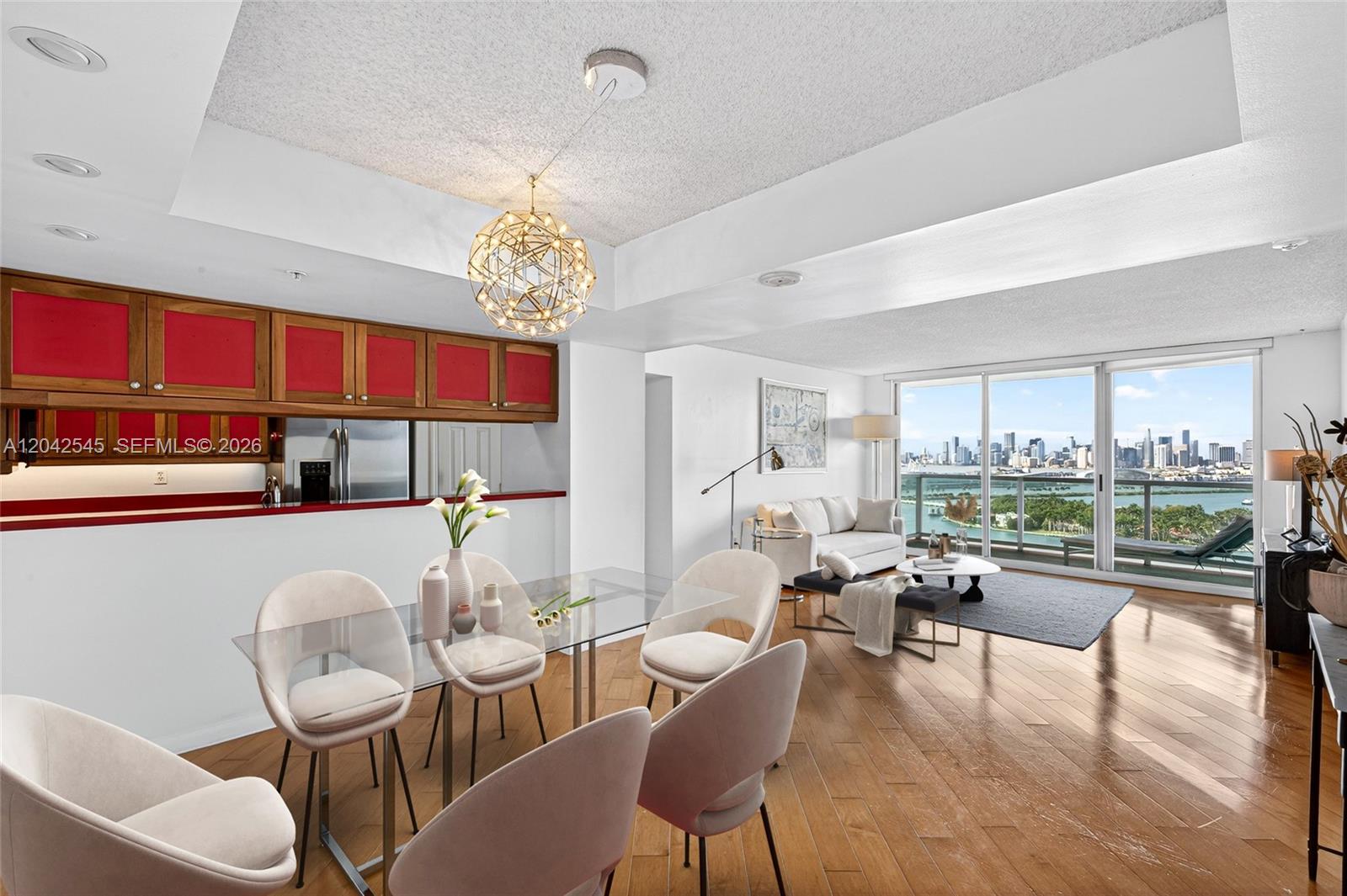 A dining area and living room with a city skyline view through floor-to-ceiling windows — MIAMI BEACH, FL