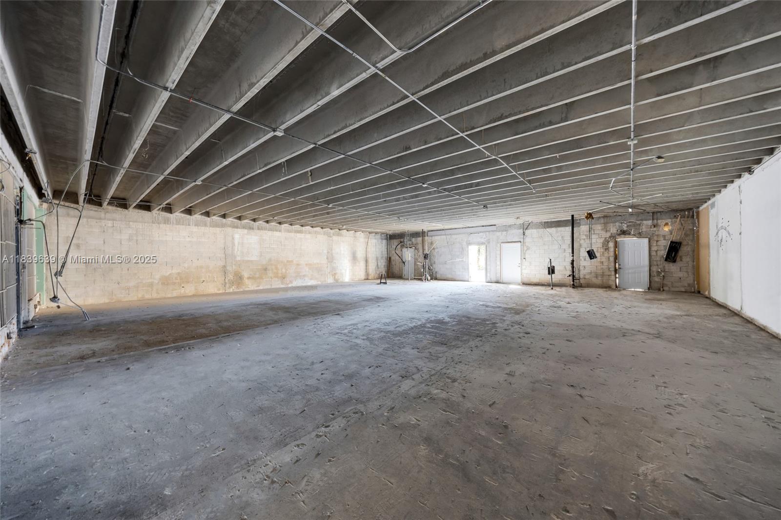 An unfinished industrial space features exposed concrete ceilings, block walls, and a concrete floor — 1544 W Flagler St, Miami FL 33135, MIAMI, FL